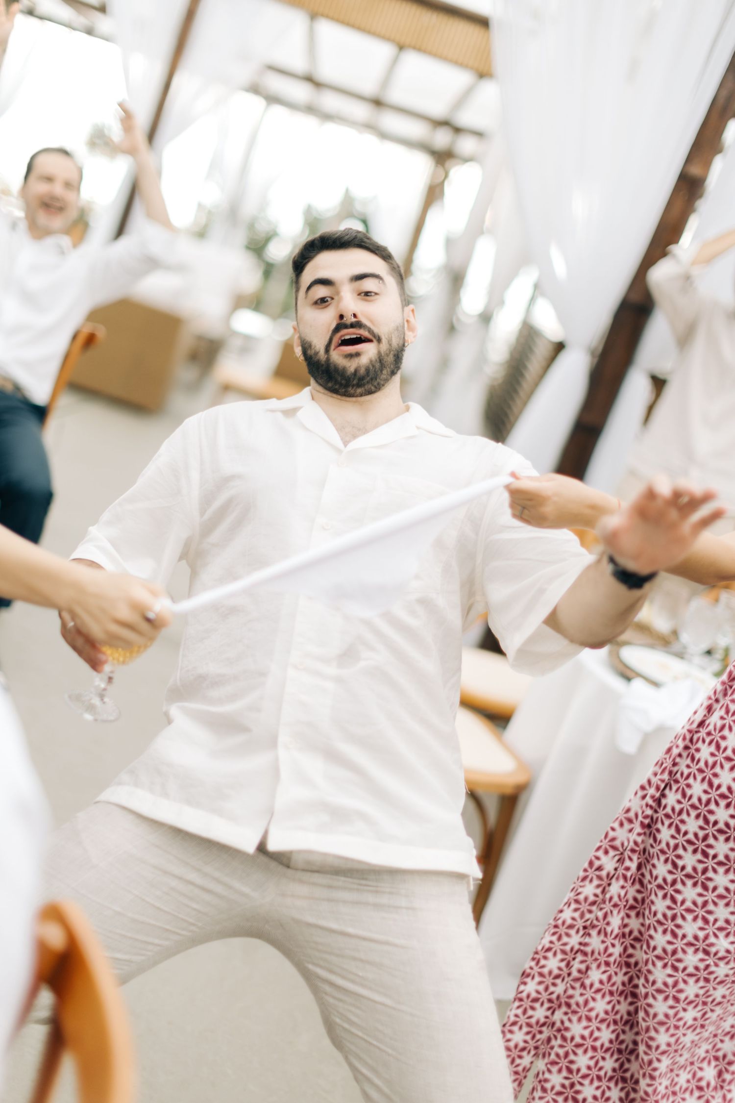 Guest in white shirt dances enthusiastically at wedding reception.