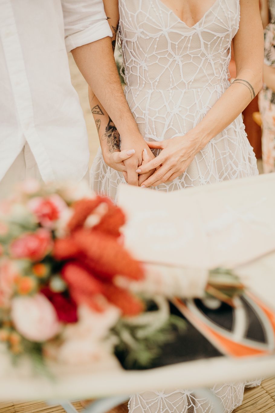 A wedding dress detail showing delicate white geometric lace pattern in an elegant design.