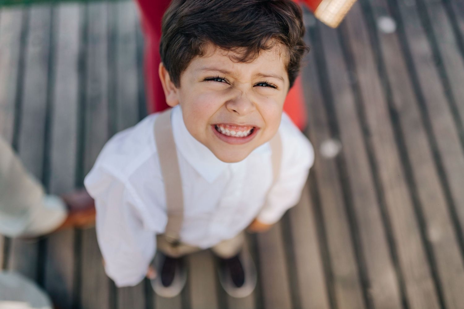 Child playing and running on wooden deck.