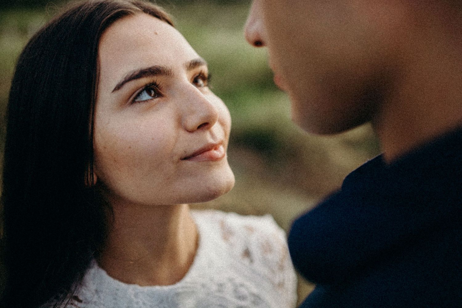 Close-up portrait of couple sharing an intimate moment outdoors.