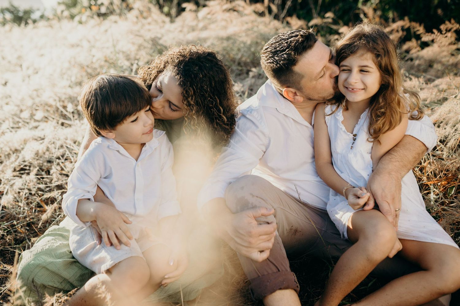 Loving family moment captured during sunset photoshoot in nature.
