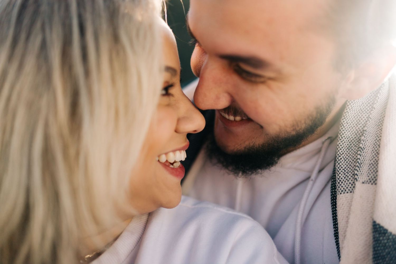 A close-up portrait of a couple sharing a tender moment and laughing together.