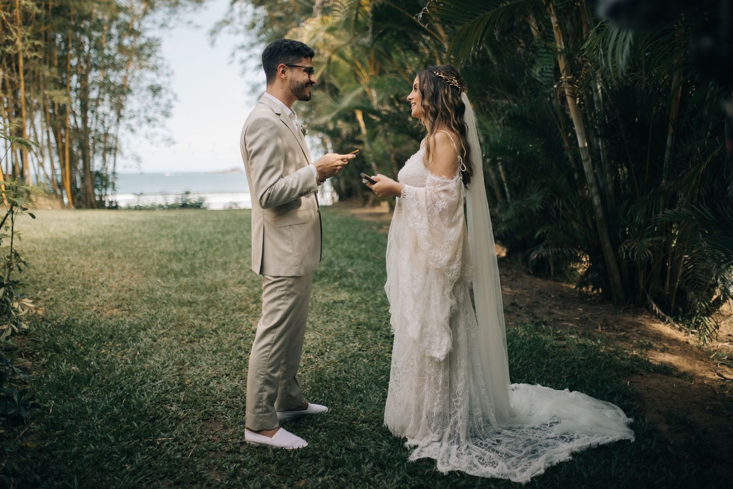 Destination wedding ceremony in tropical setting with couple exchanging vows among palm trees.