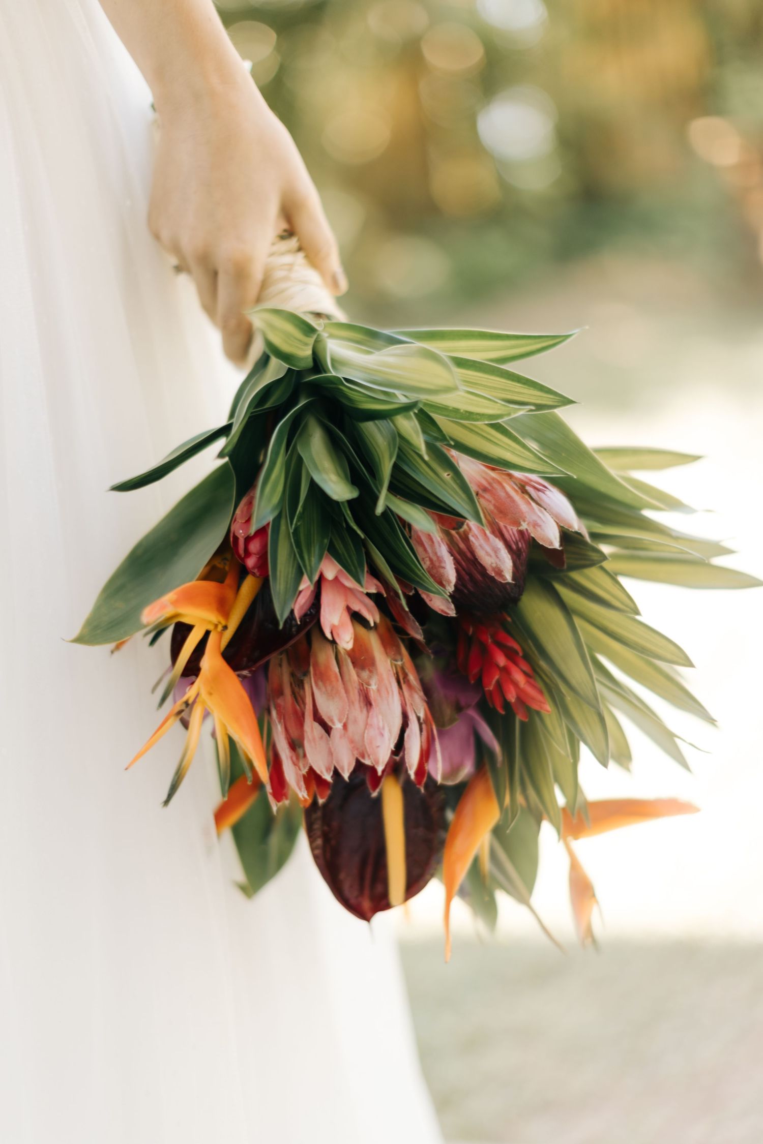 Close-up of tropical wedding bouquet with birds of paradise and greenery.