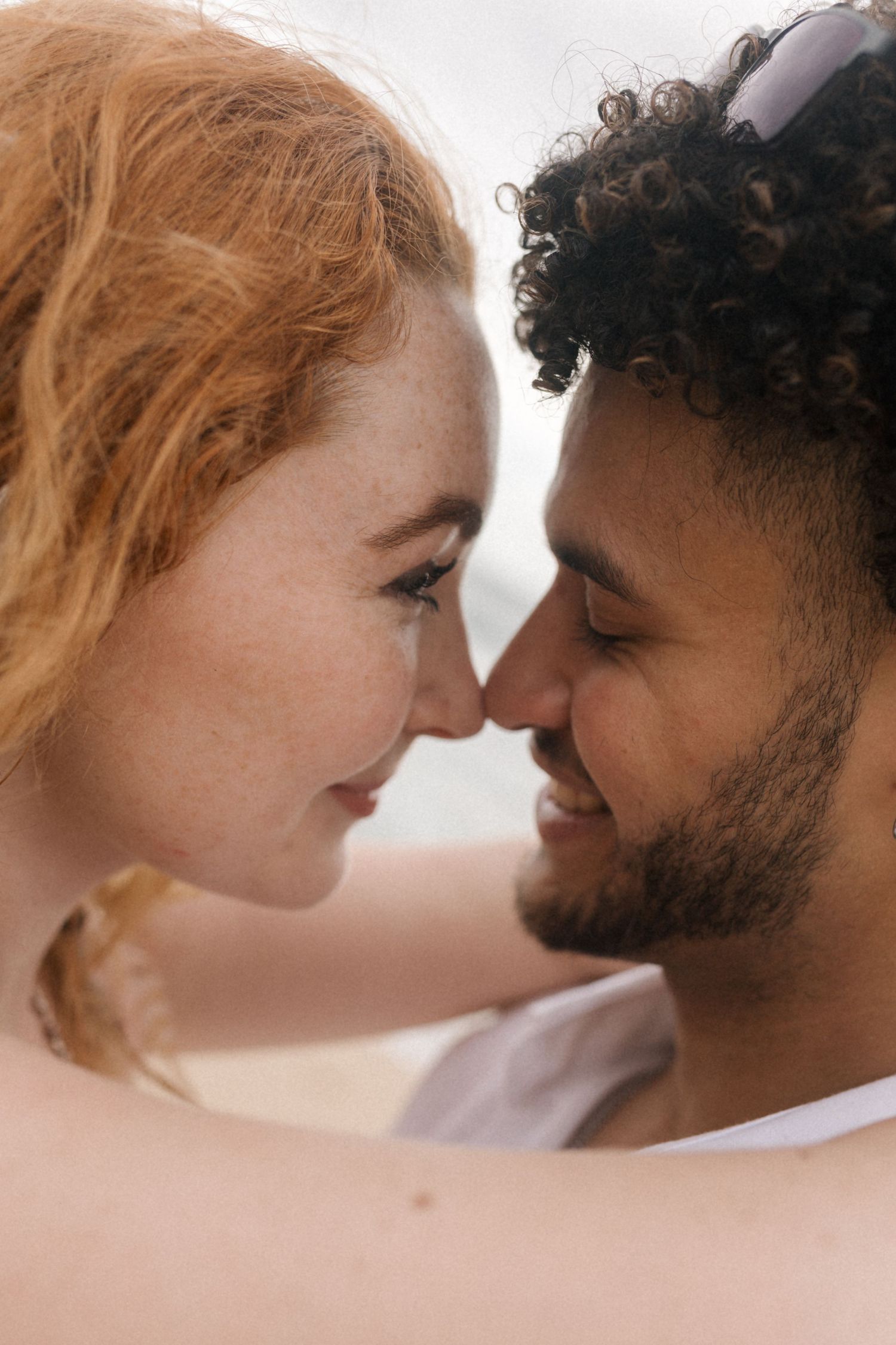 A romantic couple shares intimate moments in a series of close-up portraits against a light background.