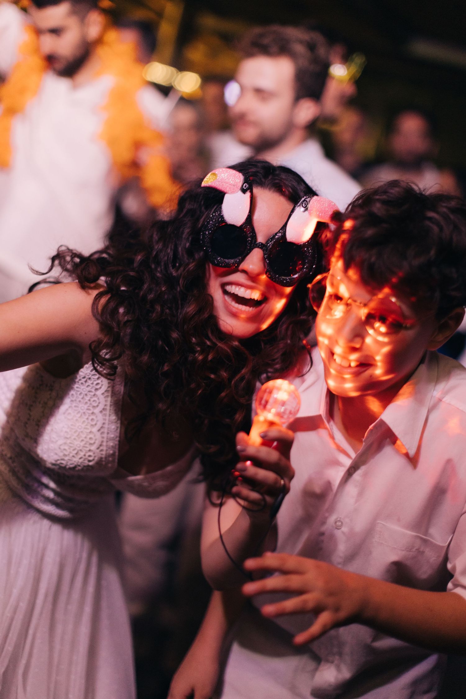 Wedding celebration with fun sunglasses and dancing at nighttime reception.