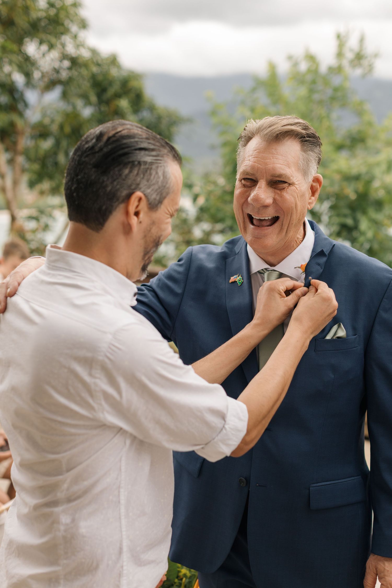 Two wedding guests sharing an emotional moment at an outdoor celebration.
