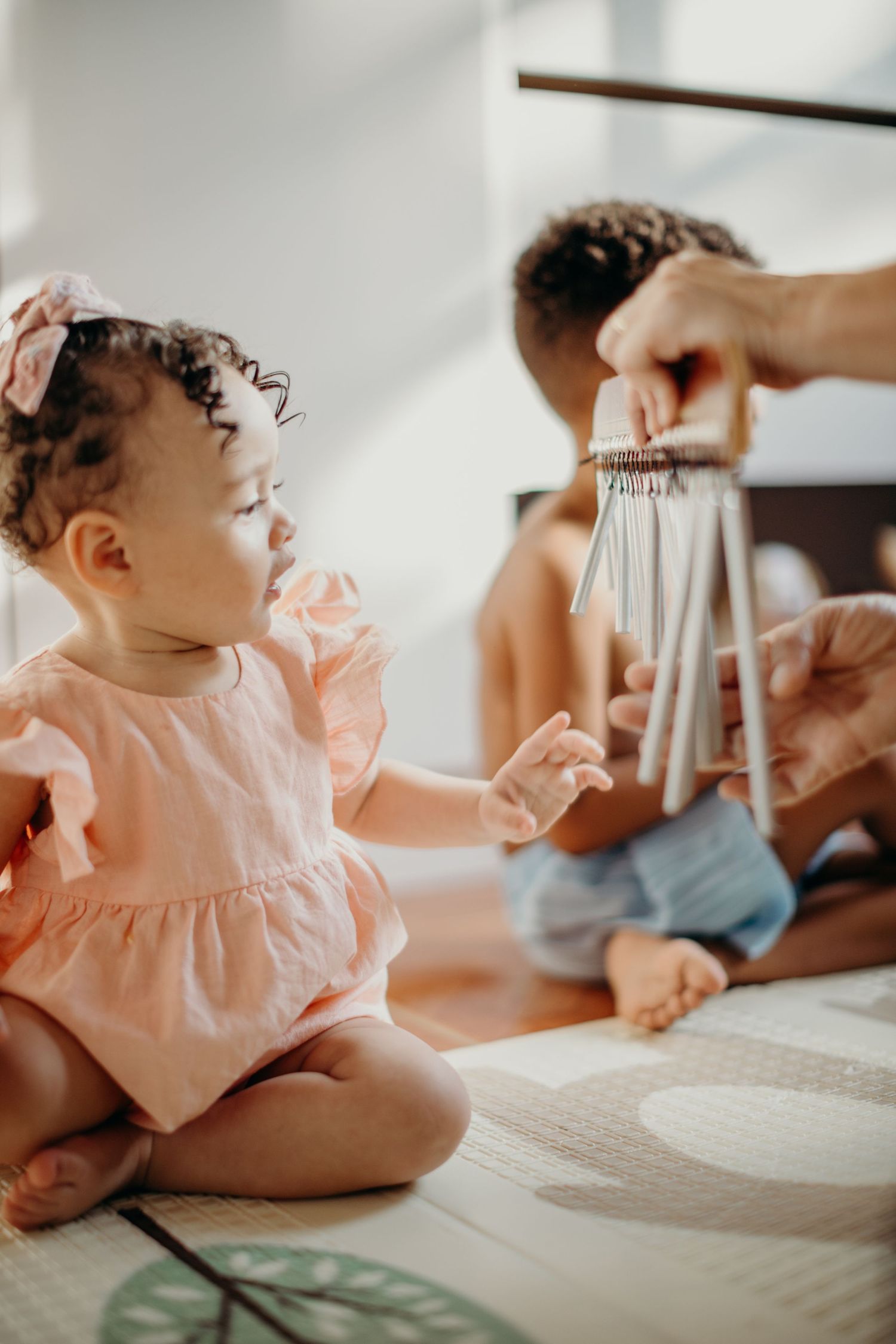 A musical interaction using chimes with a small child in a pink dress.