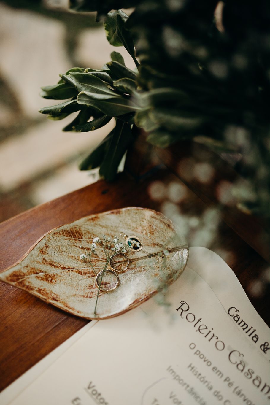 Close-up of wedding rings placed on a textured paper surface with text visible.