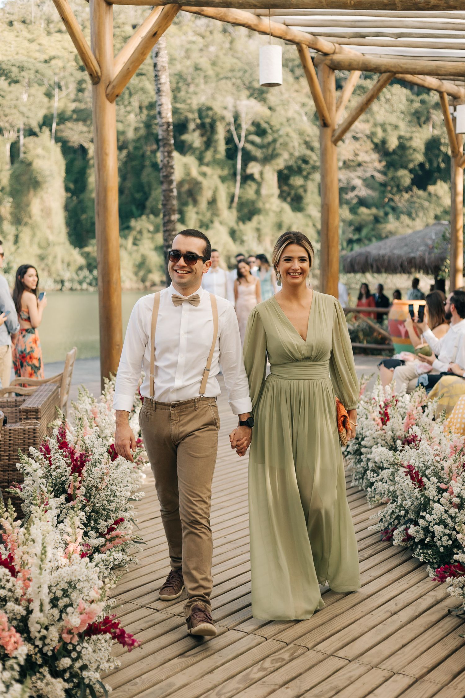 Well-dressed attendees walking down beautifully decorated outdoor walkway.