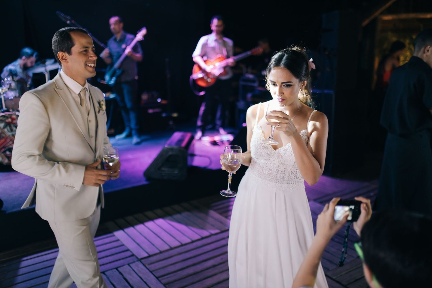 Wedding reception dance floor with live band performing in background.