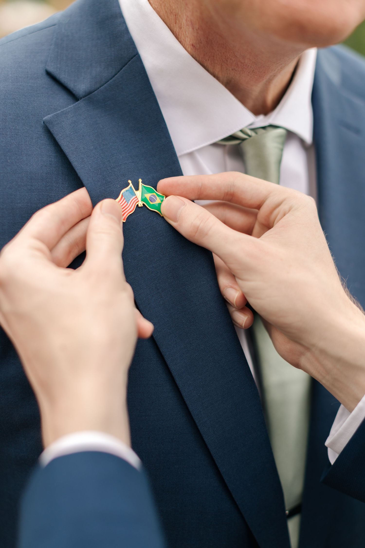 Close-up sequence of hands adjusting a blue suit tie and boutonniere.