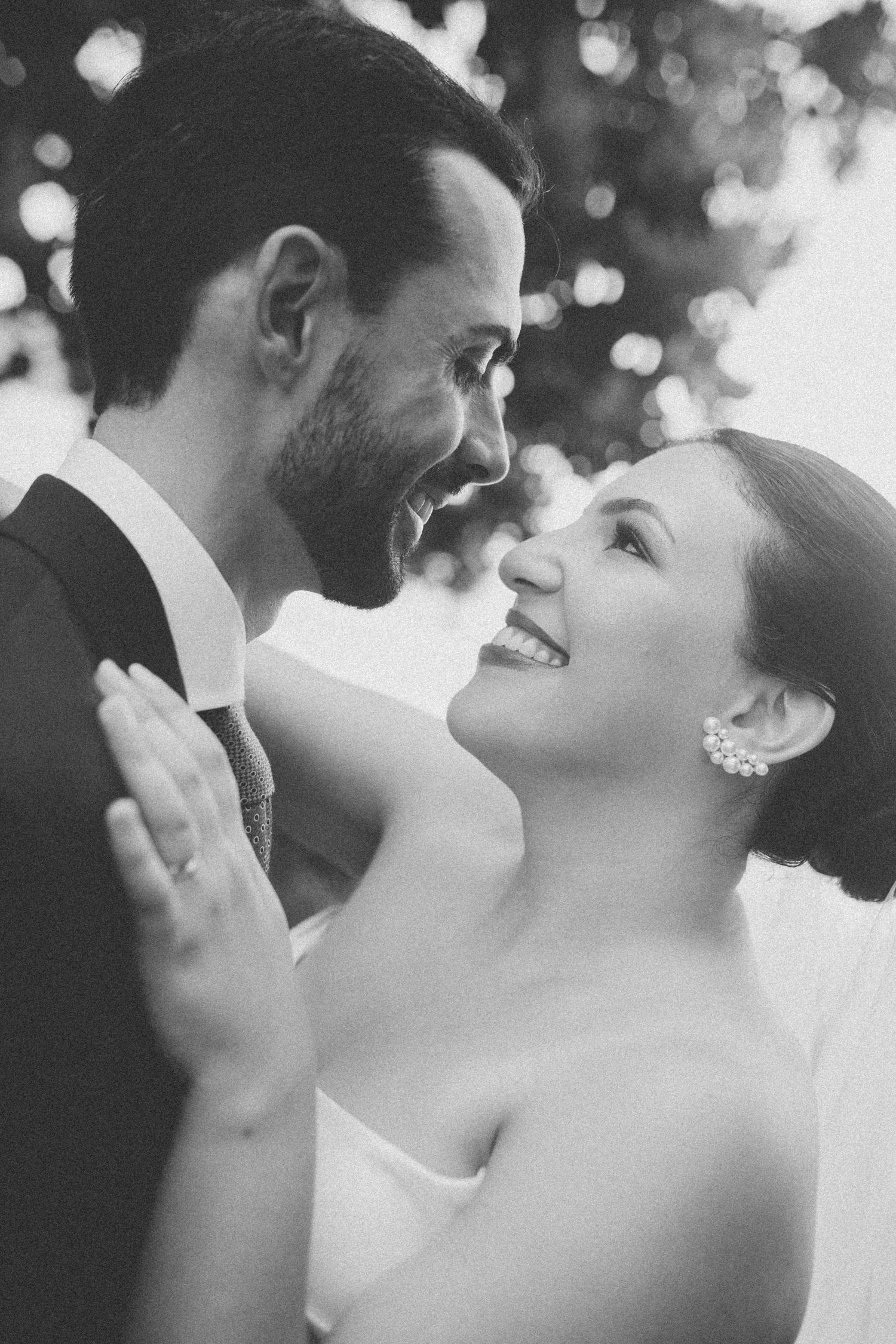 Intimate black and white portrait of newlyweds sharing a laugh during their wedding.