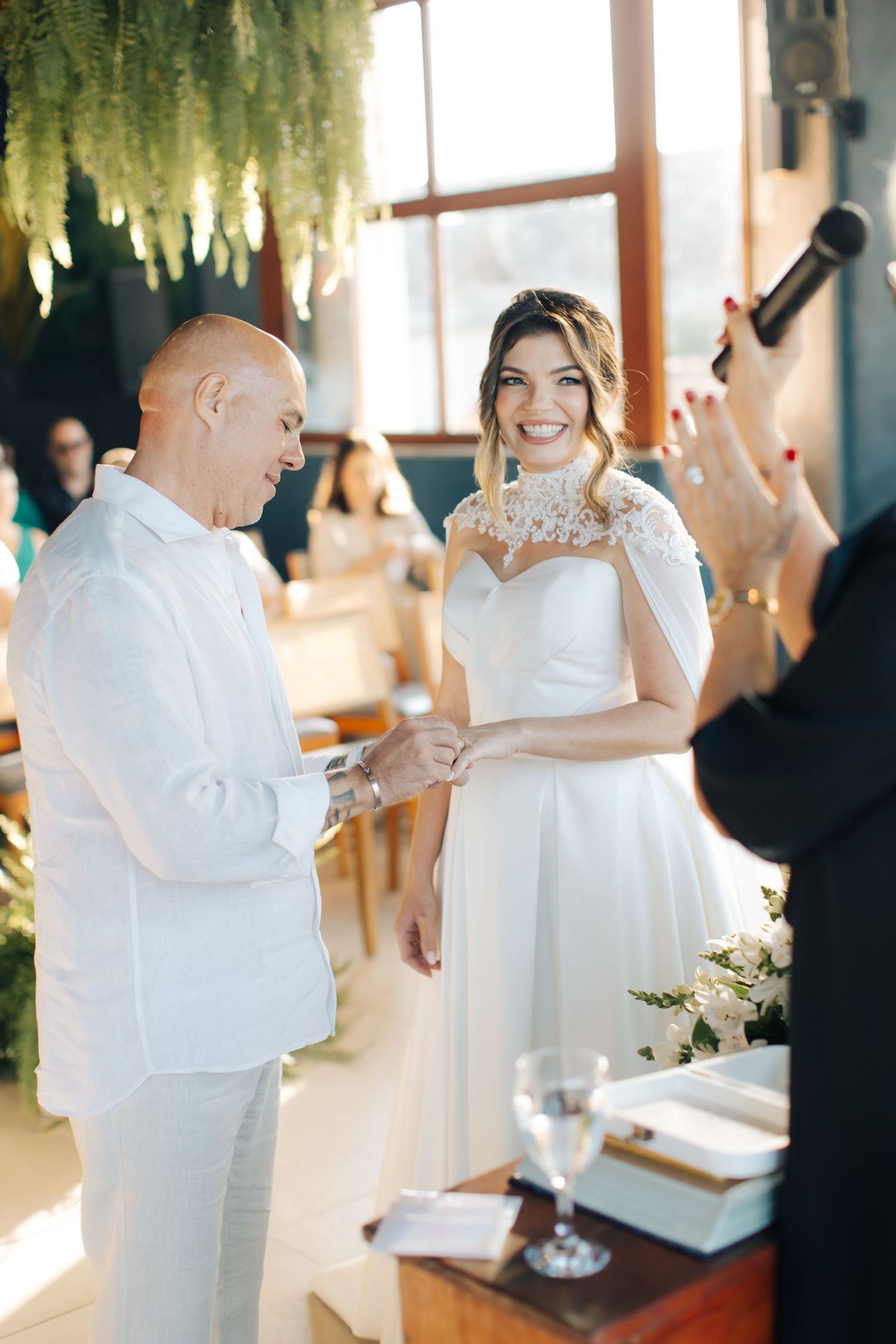 Bright indoor wedding ceremony with elegant floral decorations.