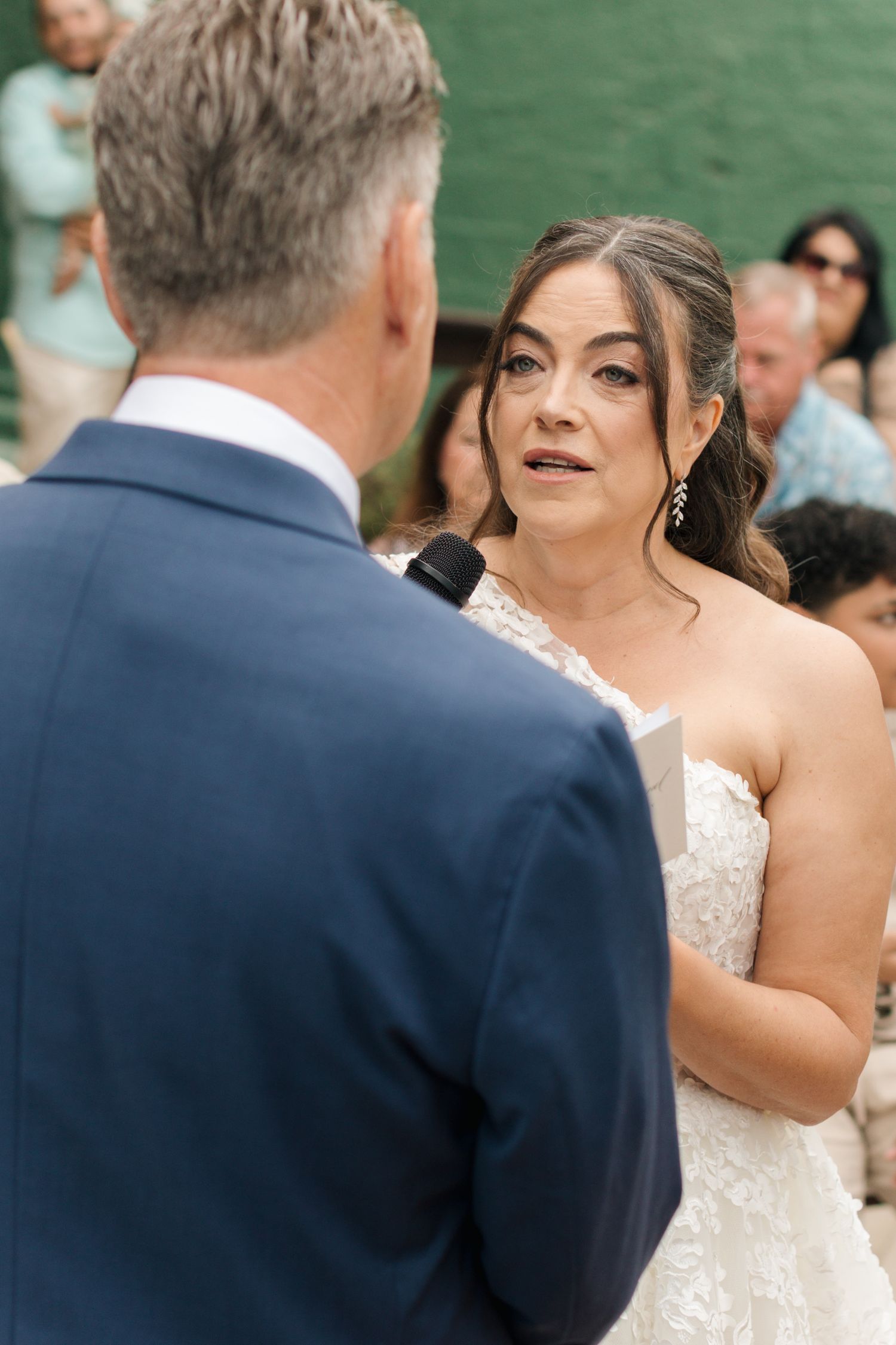 A wedding ceremony moment captured during the exchange of vows outdoors.