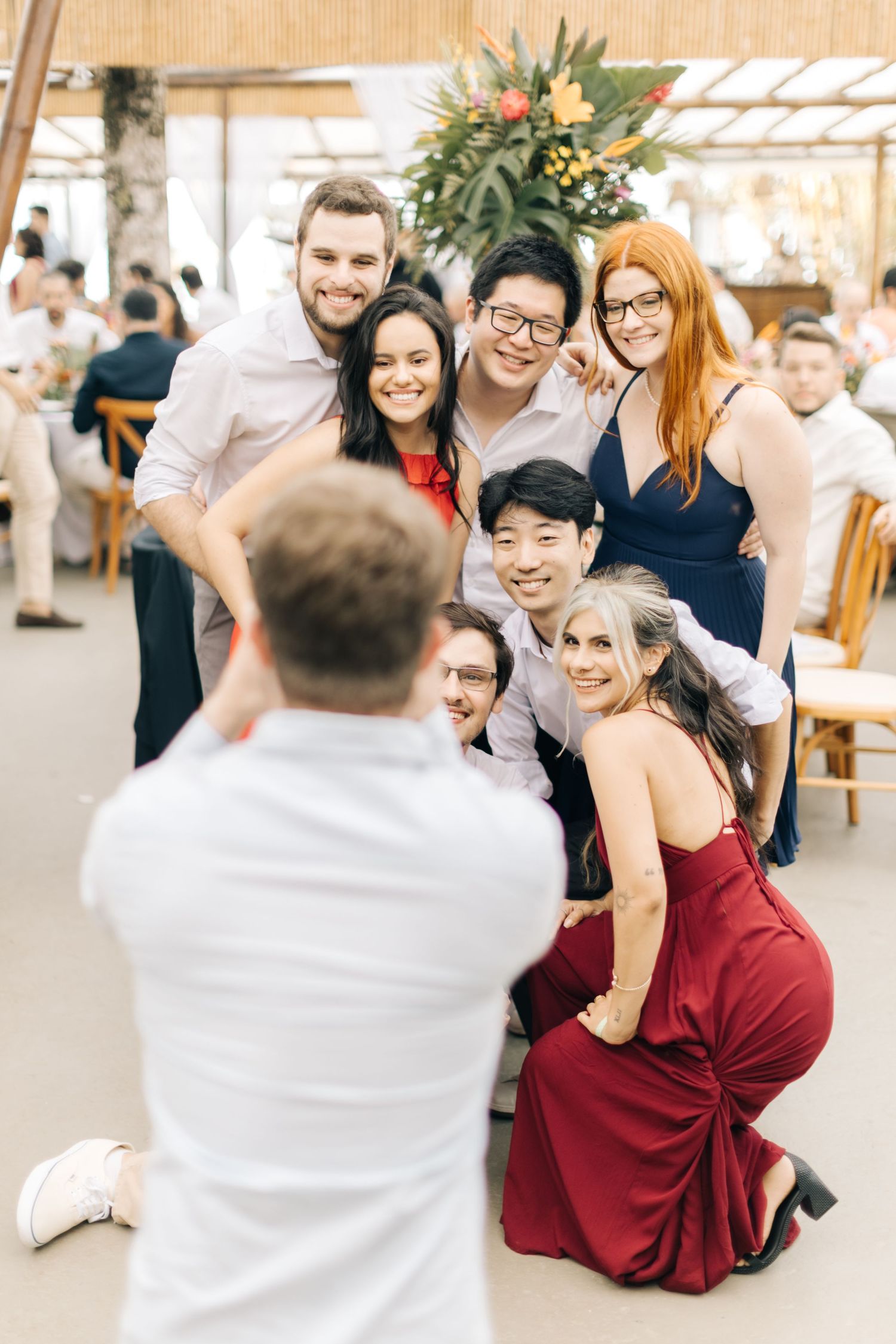 Group of wedding guests posing together for a fun photo at an indoor reception venue.