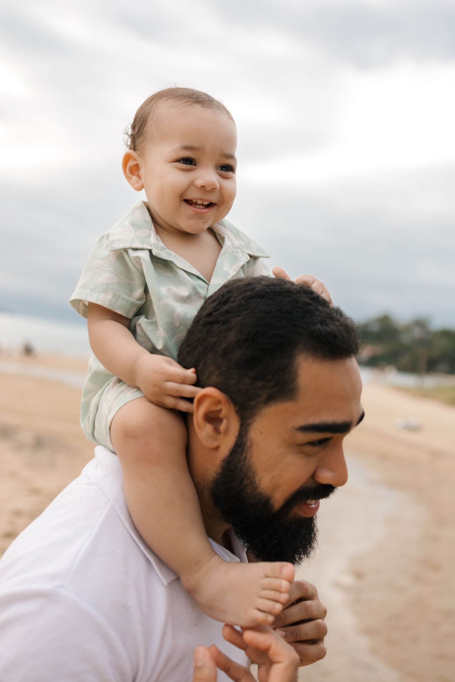 Joyful moments shared on a sandy beach with mountains visible in the distance.