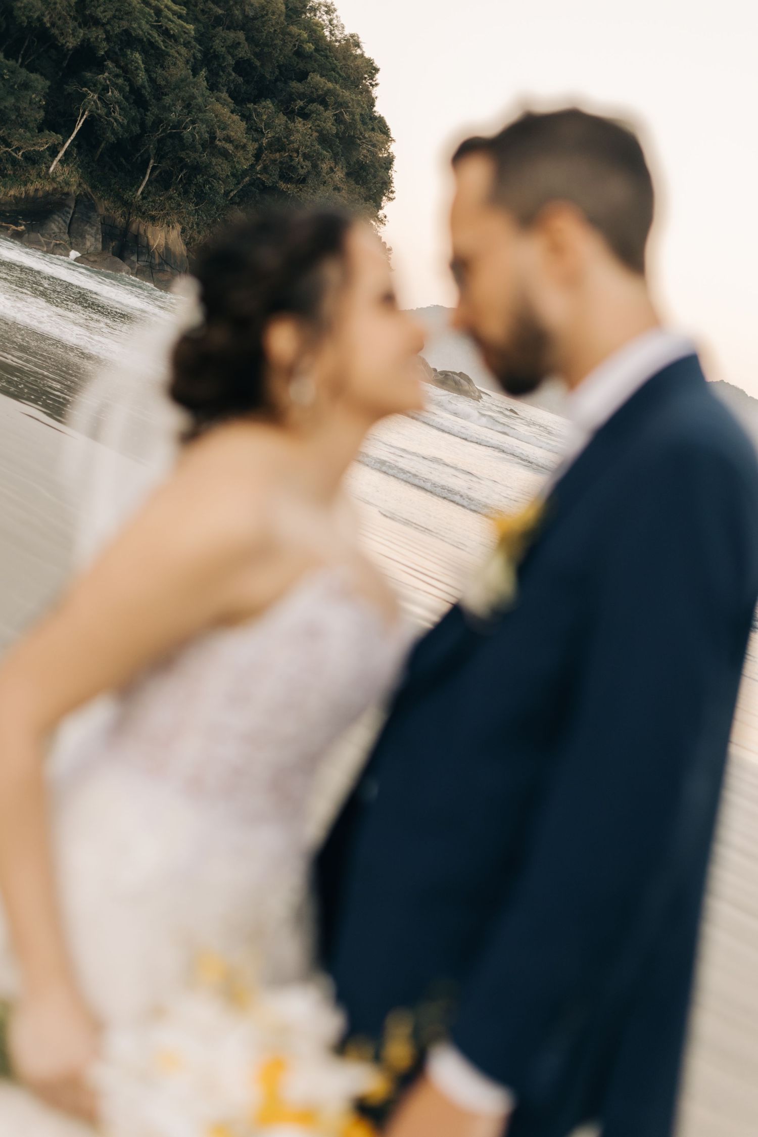 Intimate beach wedding photography session with soft lighting and coastal scenery.