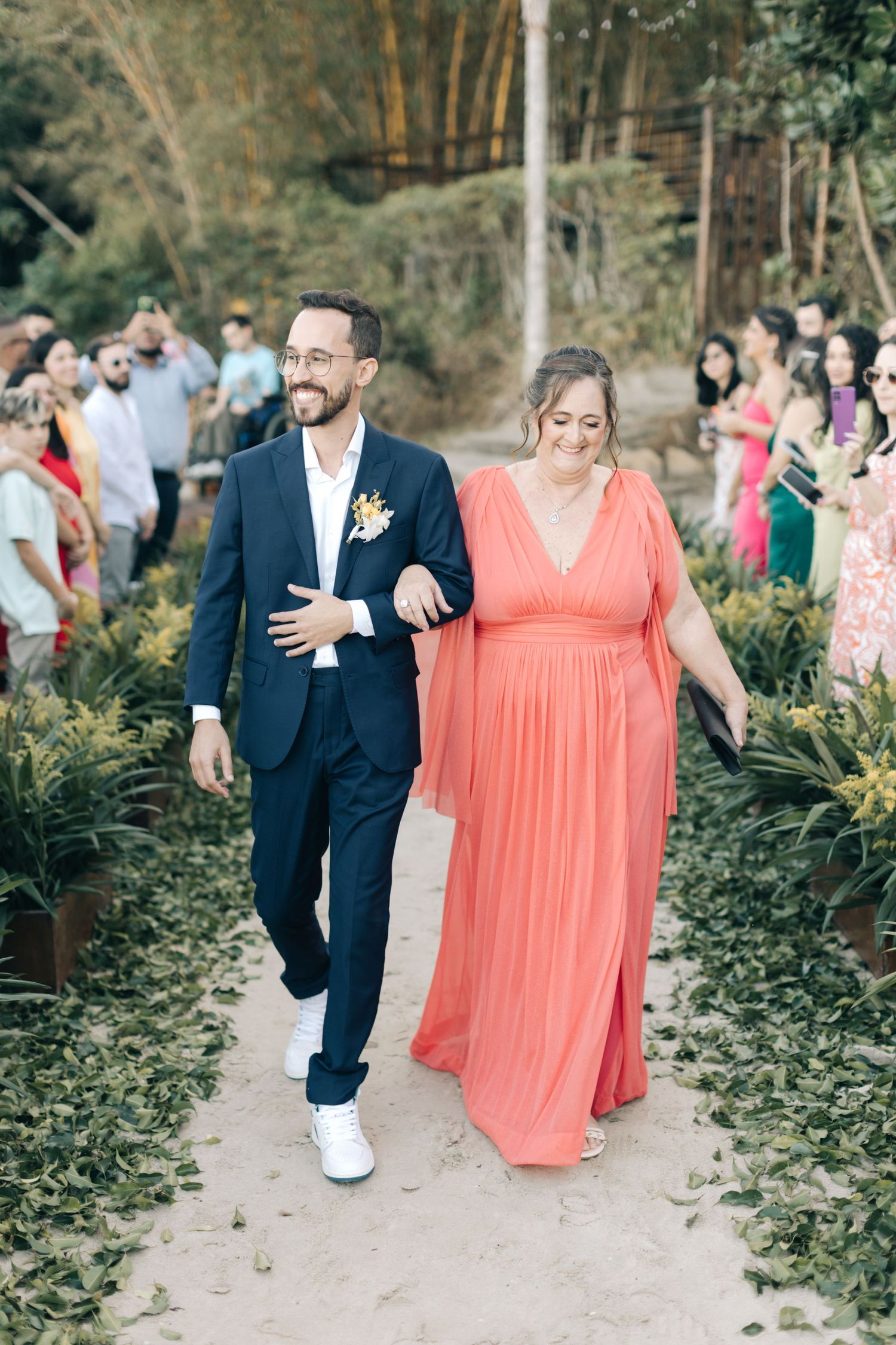 A couple walking down a garden path at a wedding ceremony.