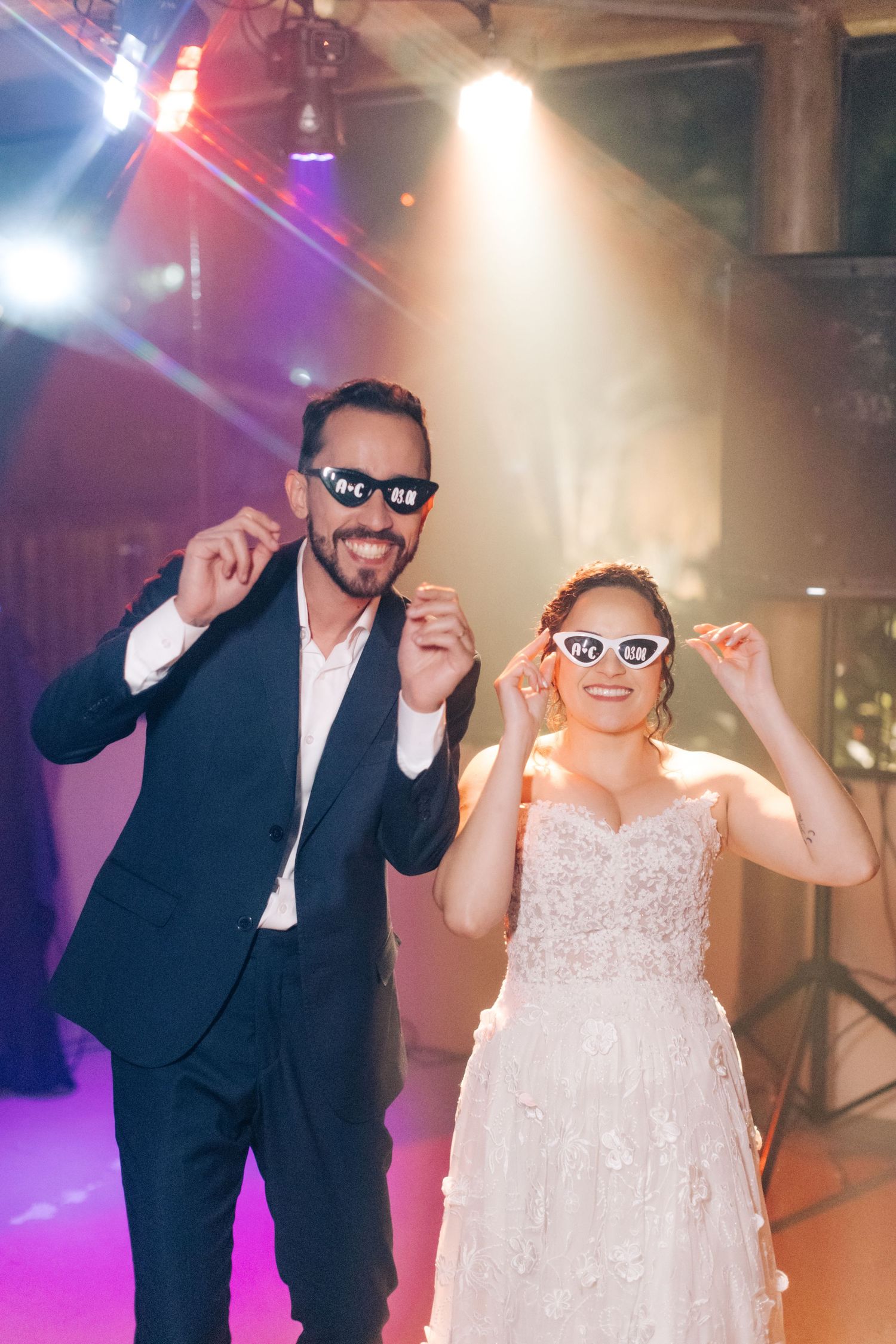 Fun dance moves under colorful spotlights during a wedding celebration.