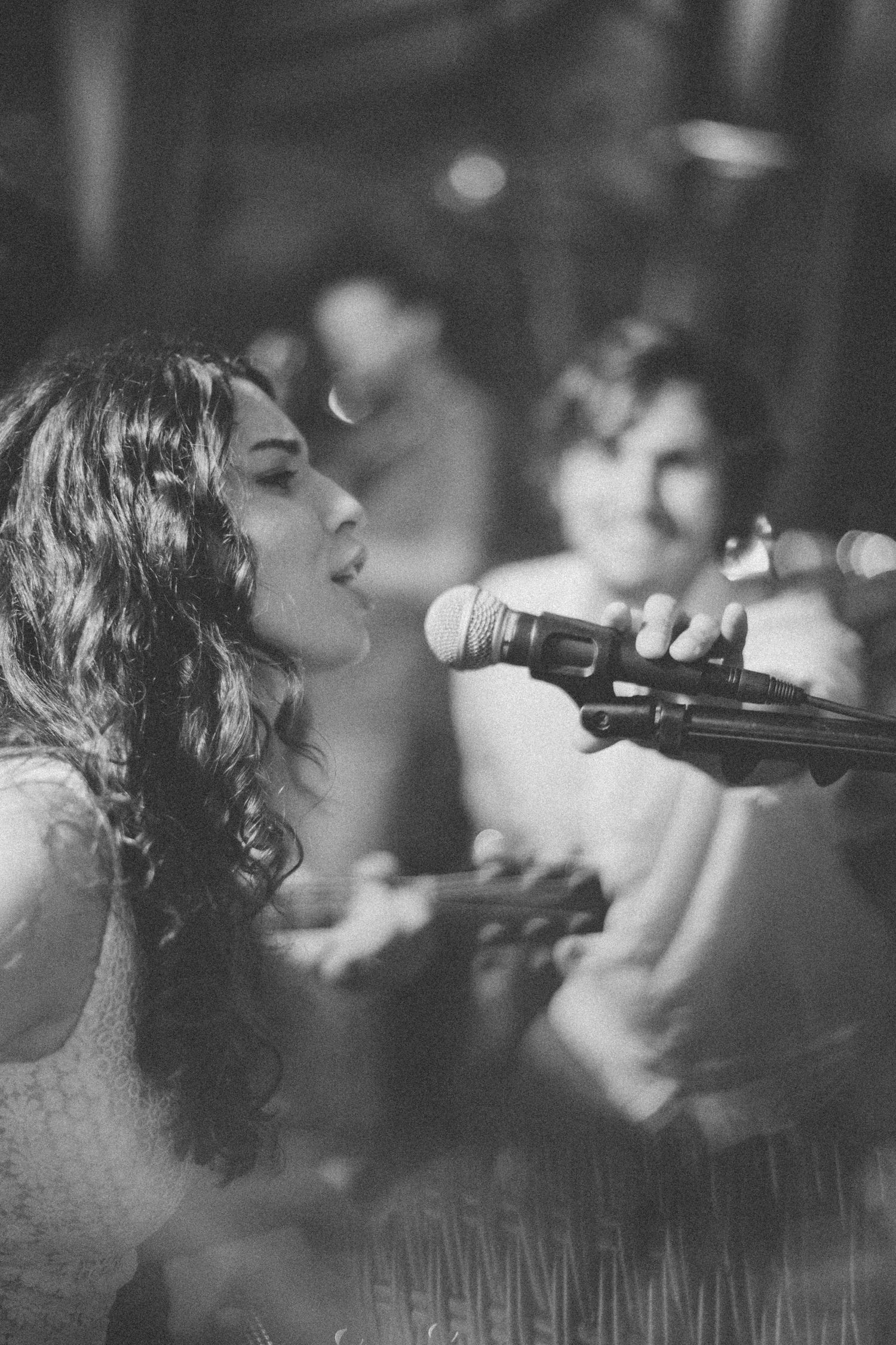 Black and white shot of singer performing passionately with microphone at event.