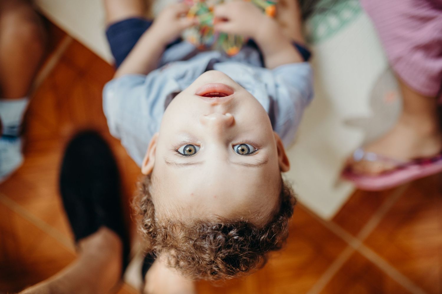 A baby lying down during an art activity session with colorful supplies nearby.