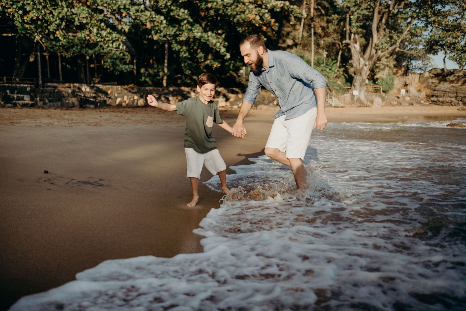People playing and jumping in ocean waves at the beach.