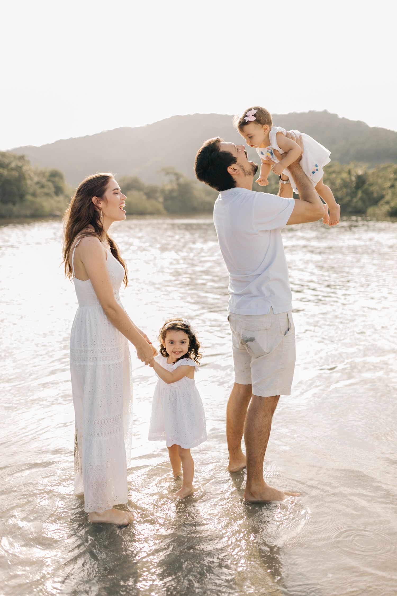 Family members having fun and playing together in shallow ocean water.
