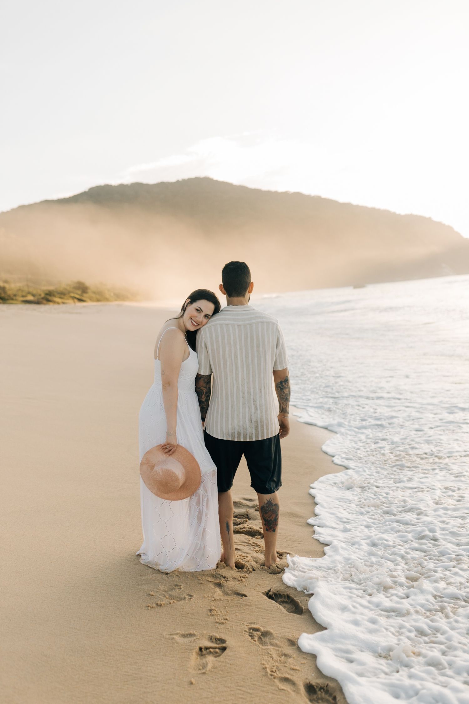 Couple enjoying a romantic beach moment while watching the waves roll in.