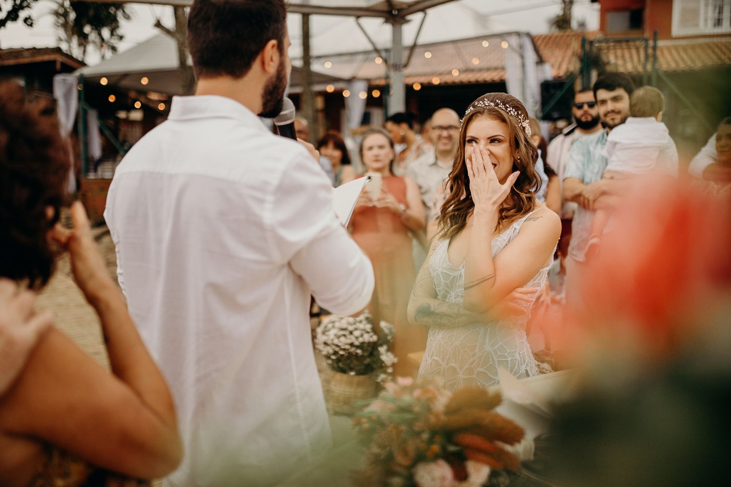 An intimate outdoor wedding moment with guests gathered around.