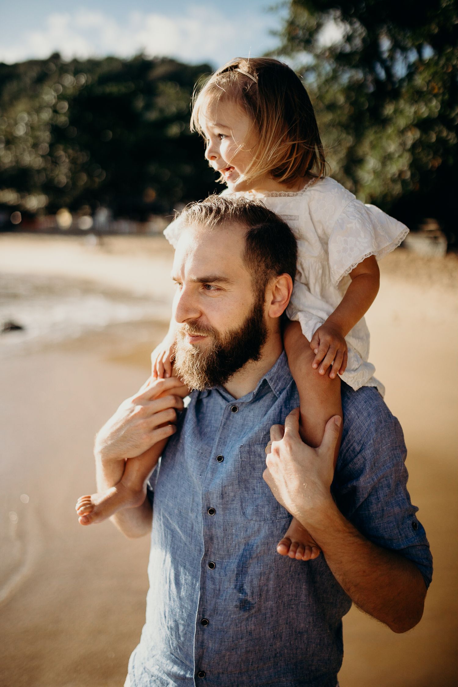 Intimate moment between parent and child playing together on a sunny beach.