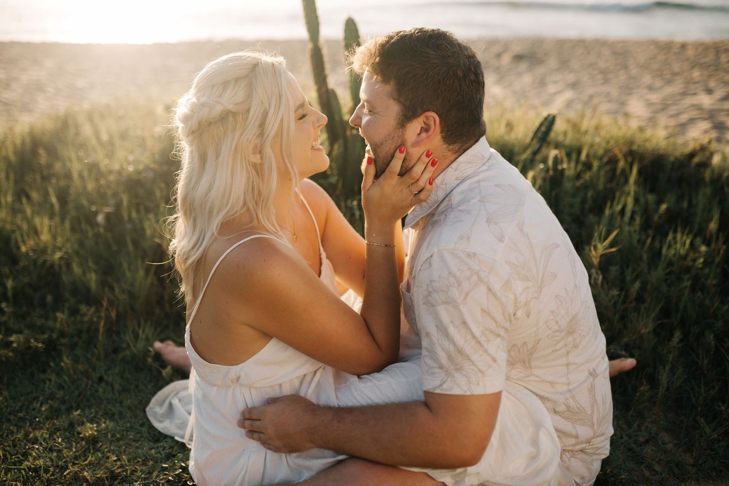 A tender embrace captured during sunset with desert vegetation in the background.