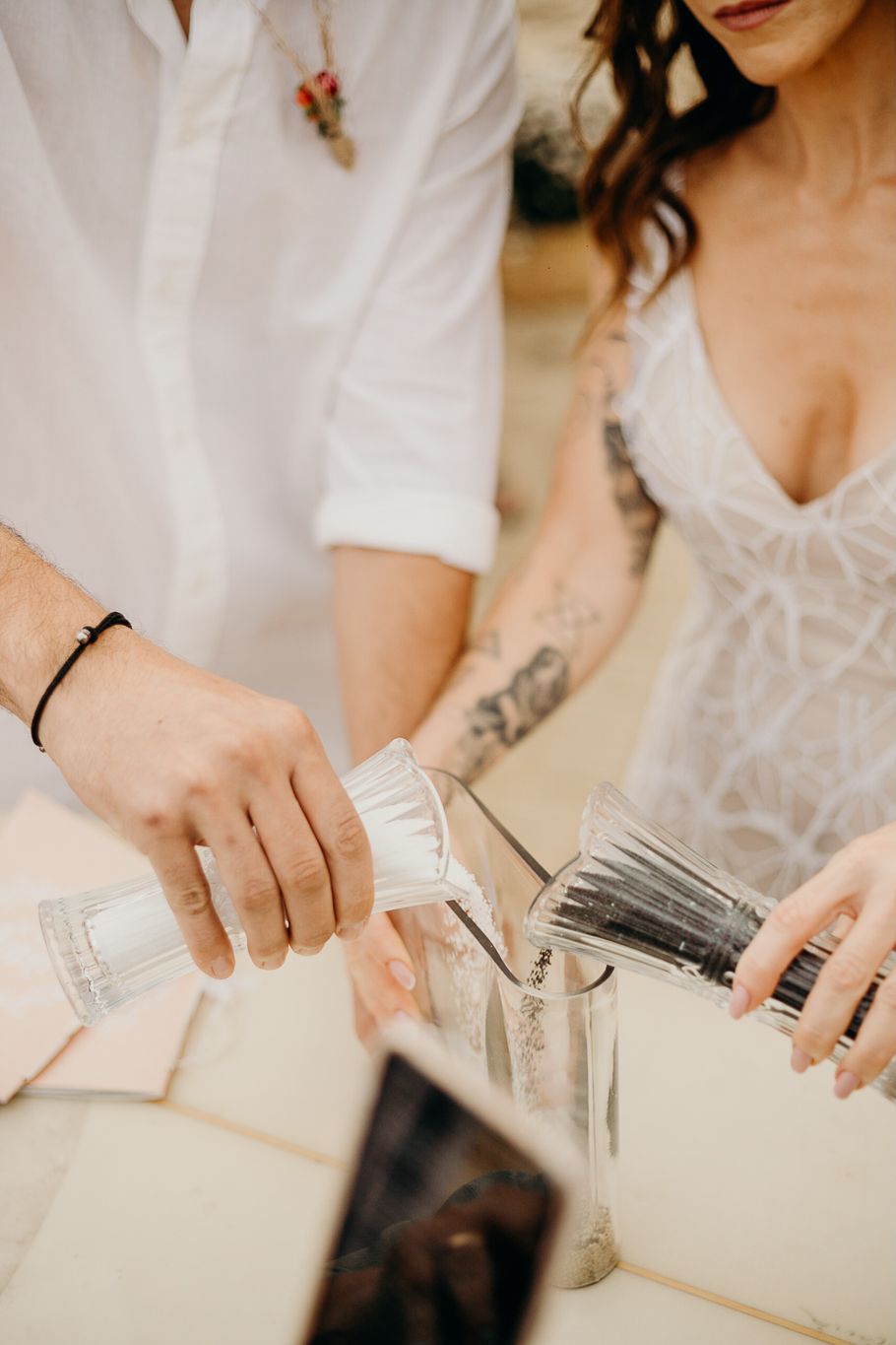 Wedding reception detail shot of hands organizing items on table.