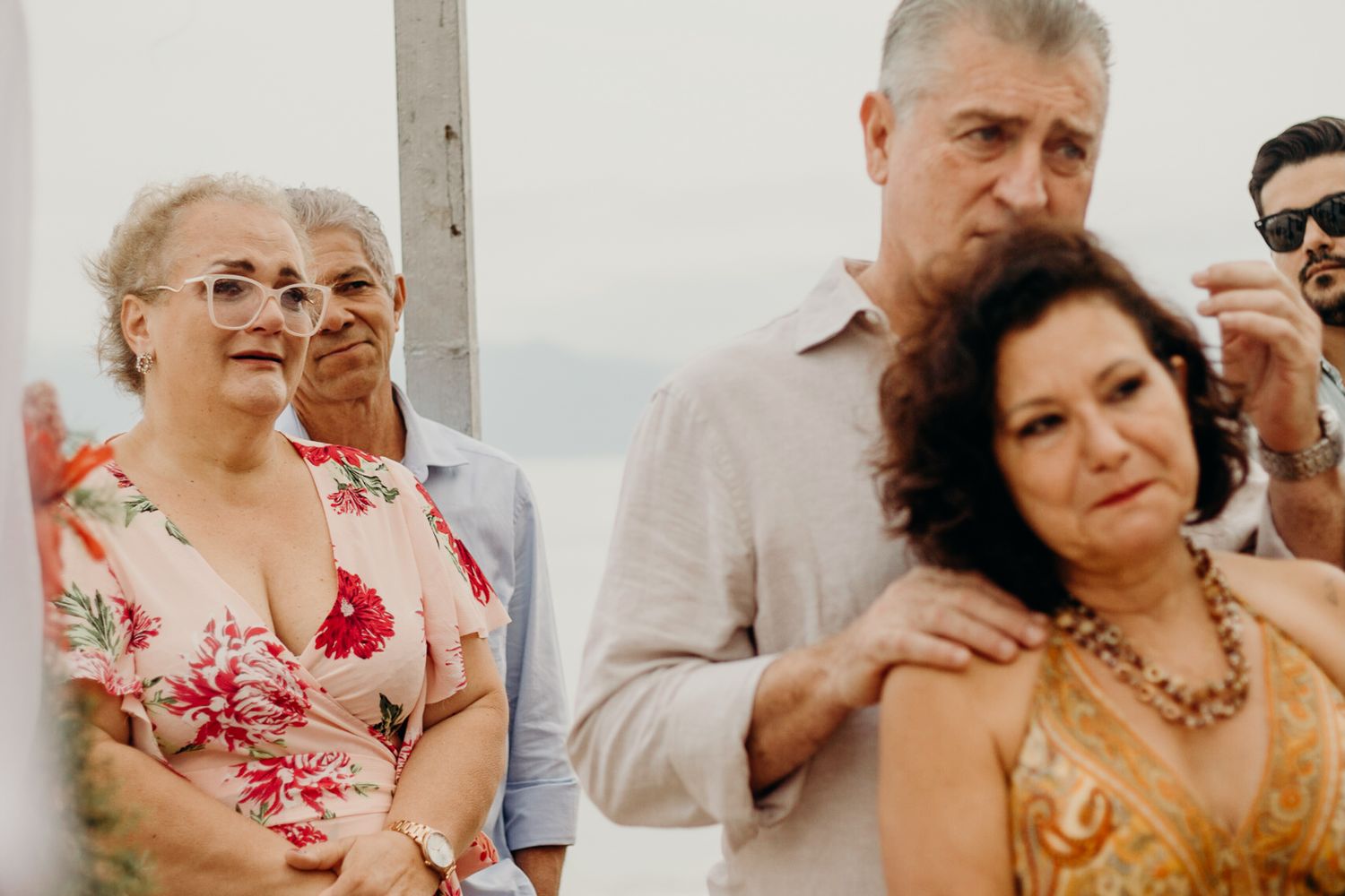 Wedding celebration with guests clapping and cheering during an outdoor beach reception.