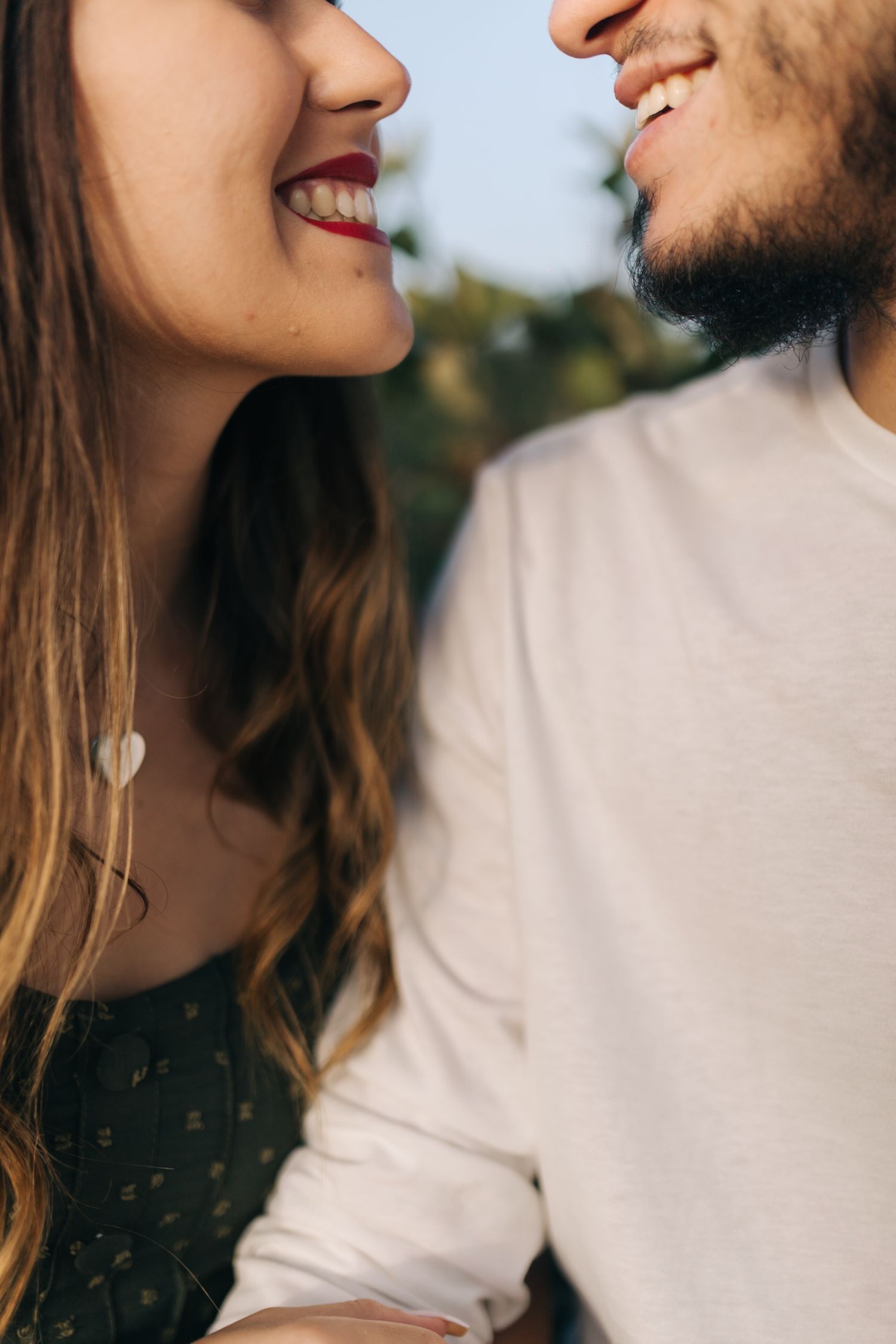 Close-up profile shot of couple sharing a laugh in natural lighting.