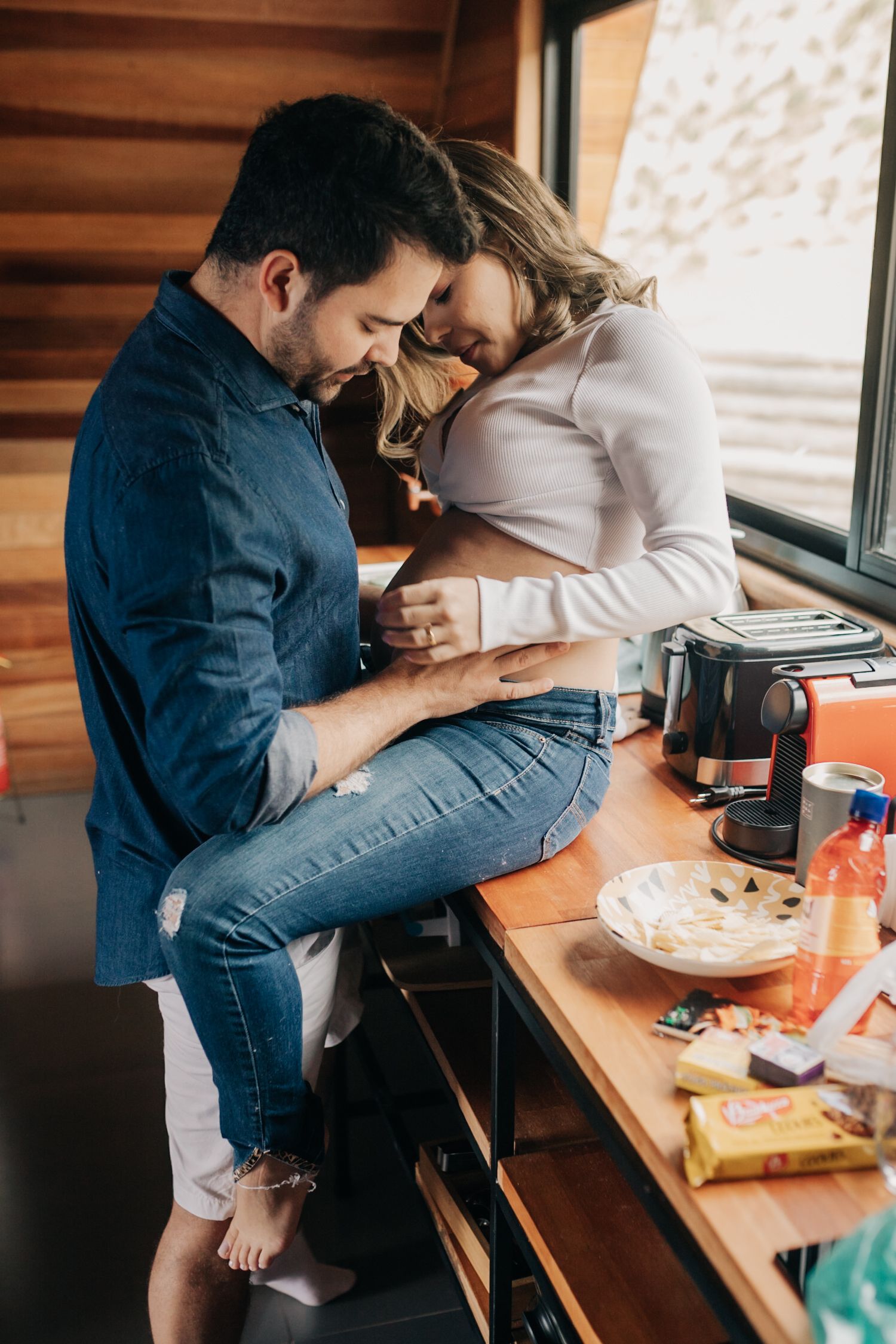 Intimate lifestyle photos of couple sharing food and laughter in rustic cabin setting.