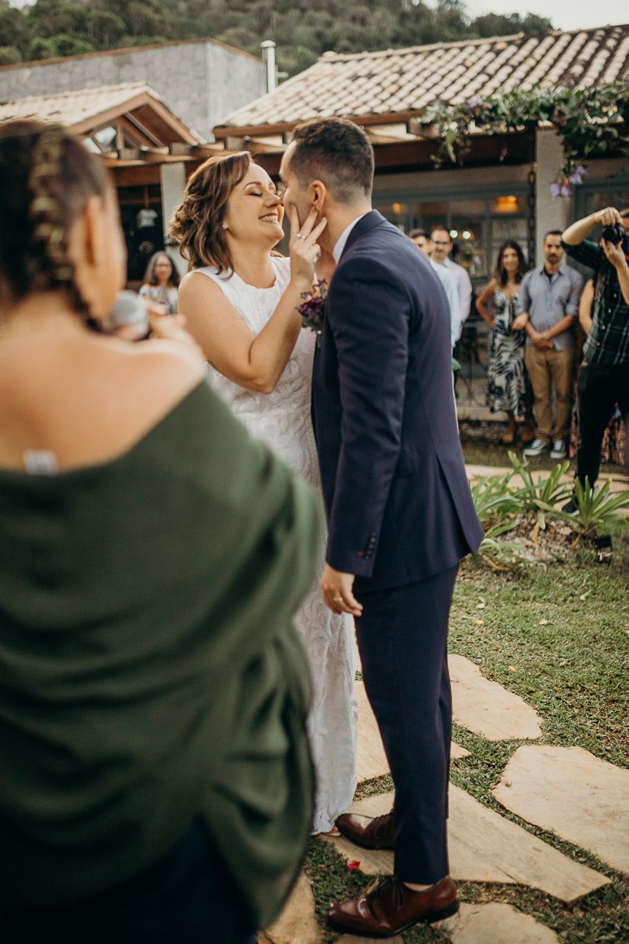 Bride and groom share an intimate moment at an outdoor wedding venue with rustic decor and garden surroundings.