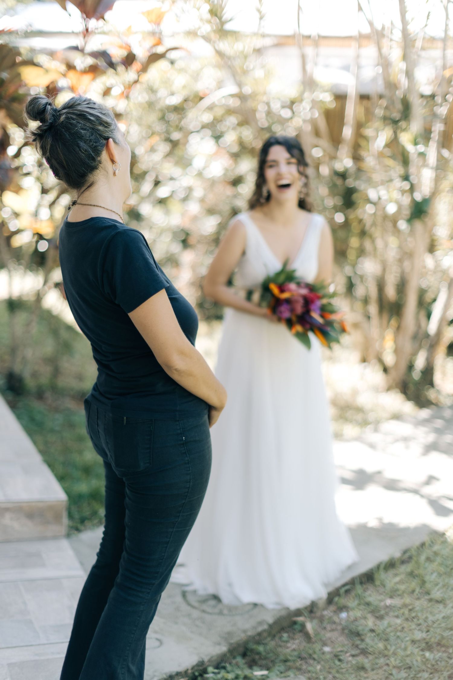 Candid moment of a photographer taking pictures of a bride in a garden setting.