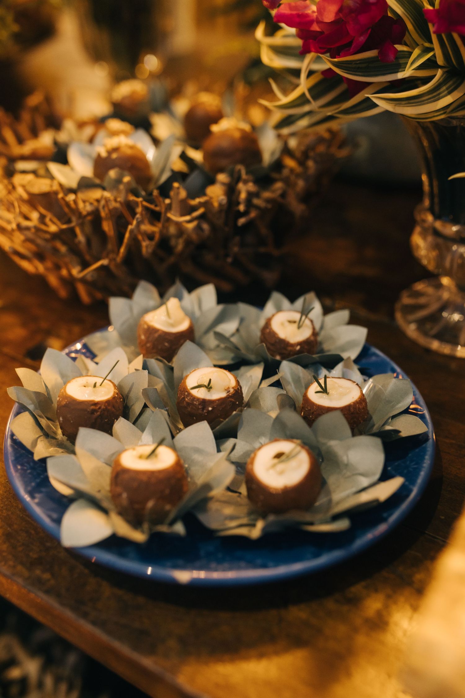 Gourmet wedding desserts presented on a blue plate with decorative paper wrappings.