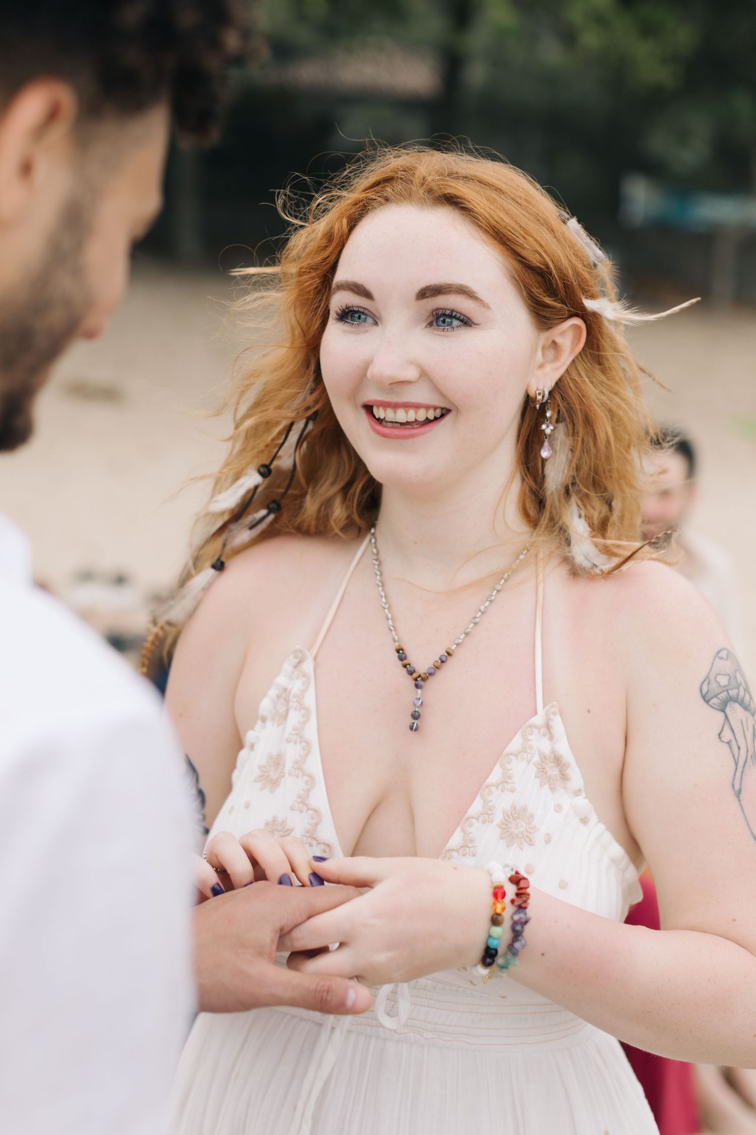Joyful moment during a beach wedding ceremony with white dress and floral decorations.