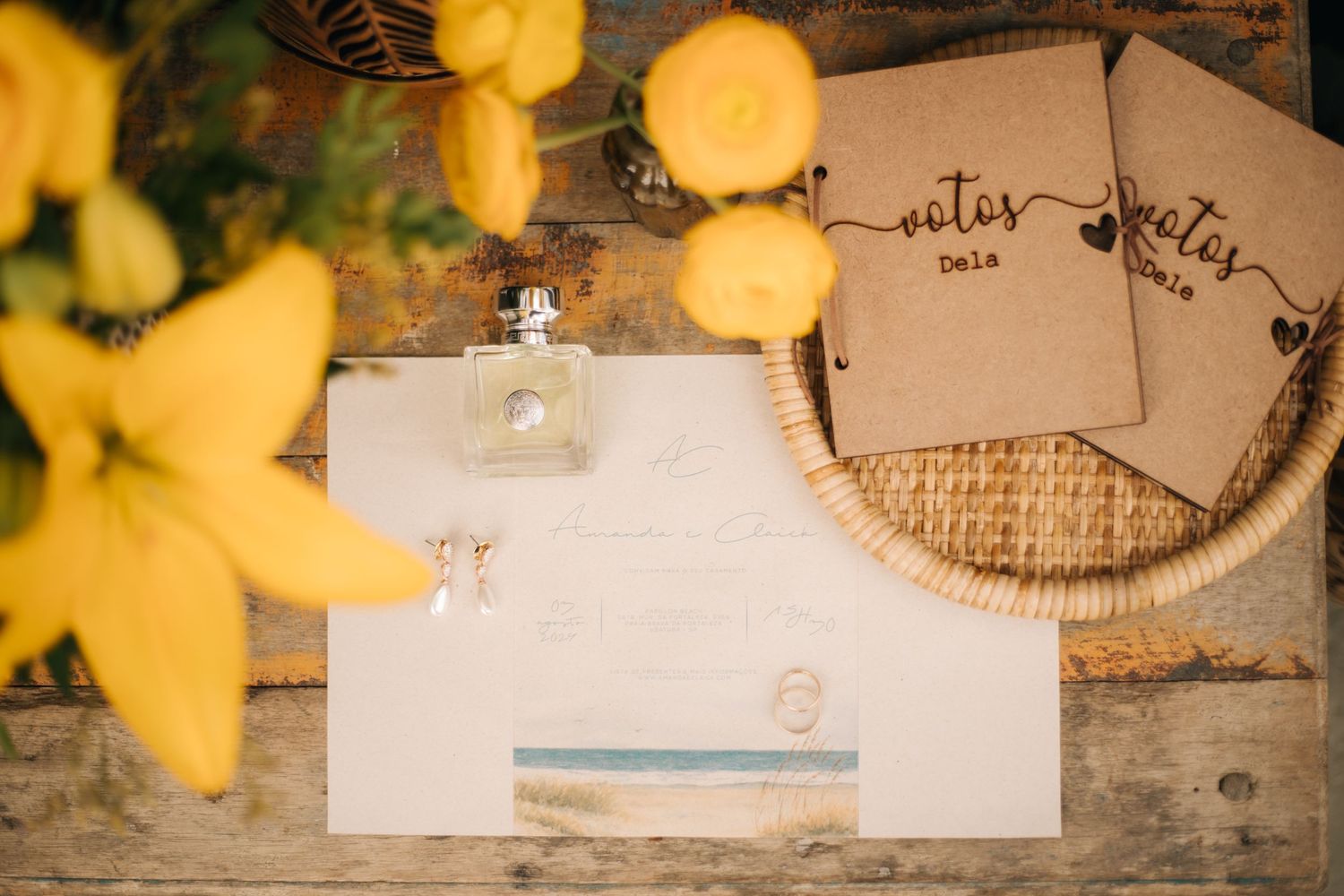 Rustic wedding stationery and notes arranged on a weathered wooden surface with yellow flowers.