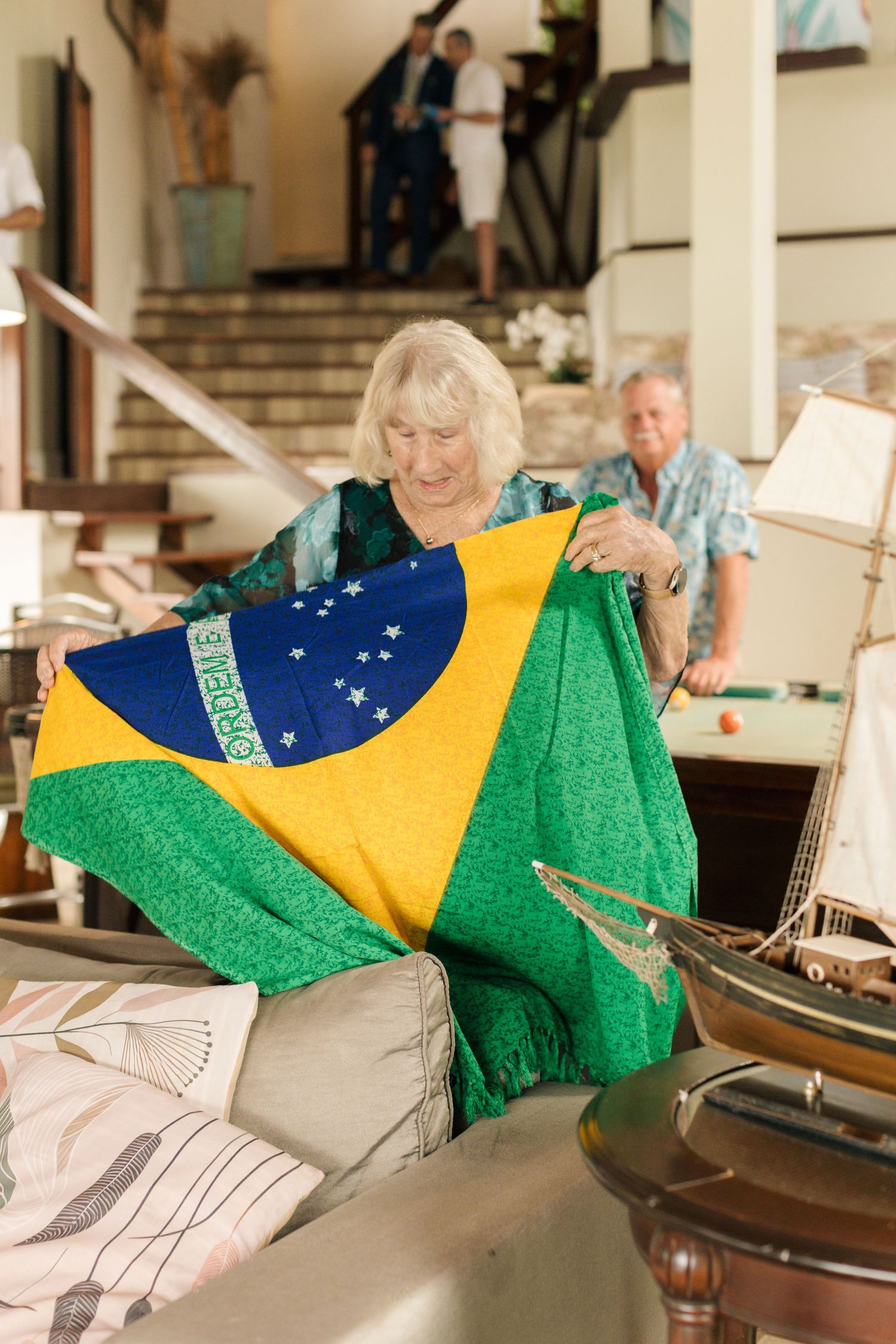The Brazilian flag is displayed in a decorative sequence across a light-colored interior.