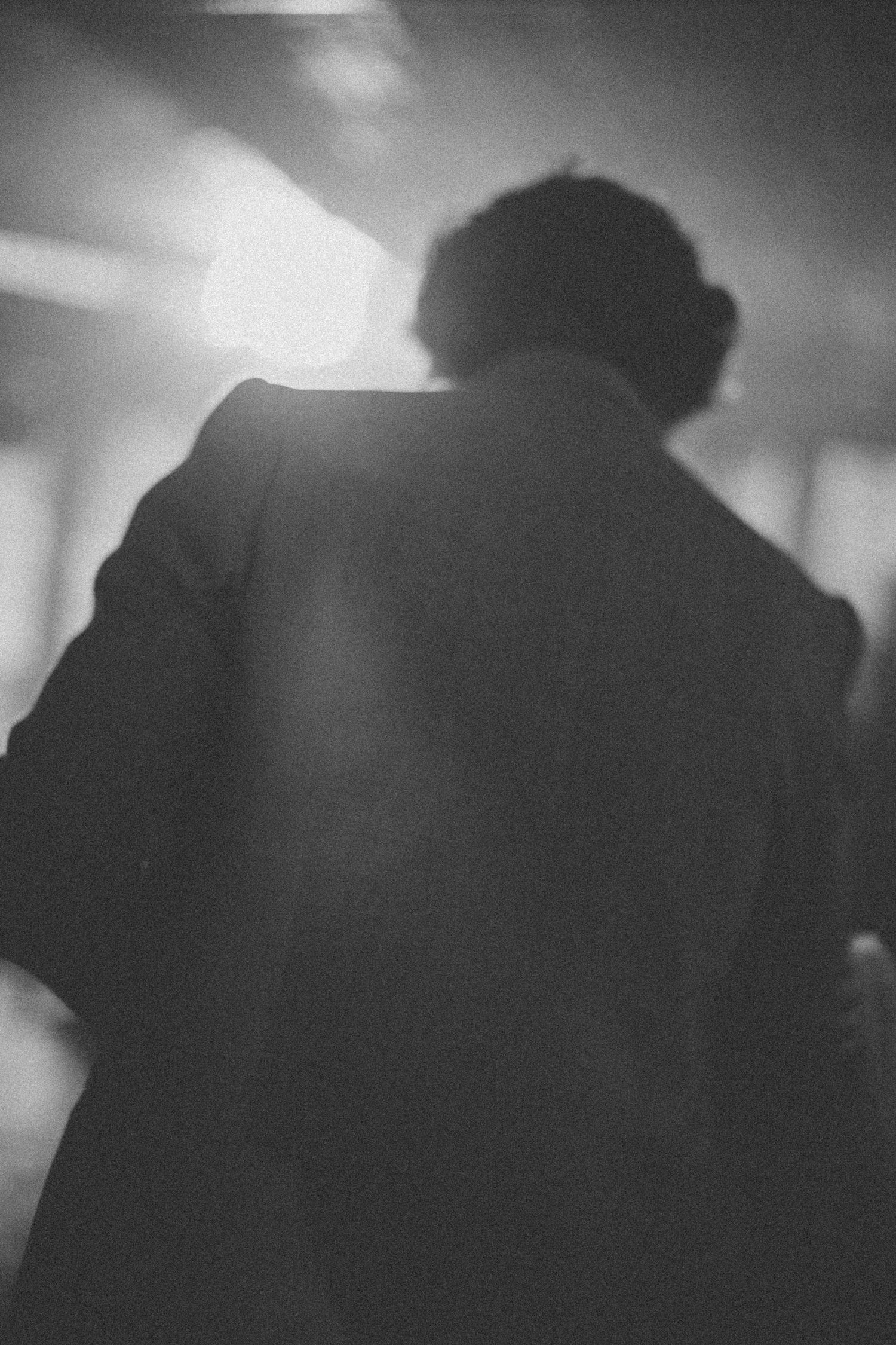 Black and white silhouettes of people dancing in atmospheric lighting.