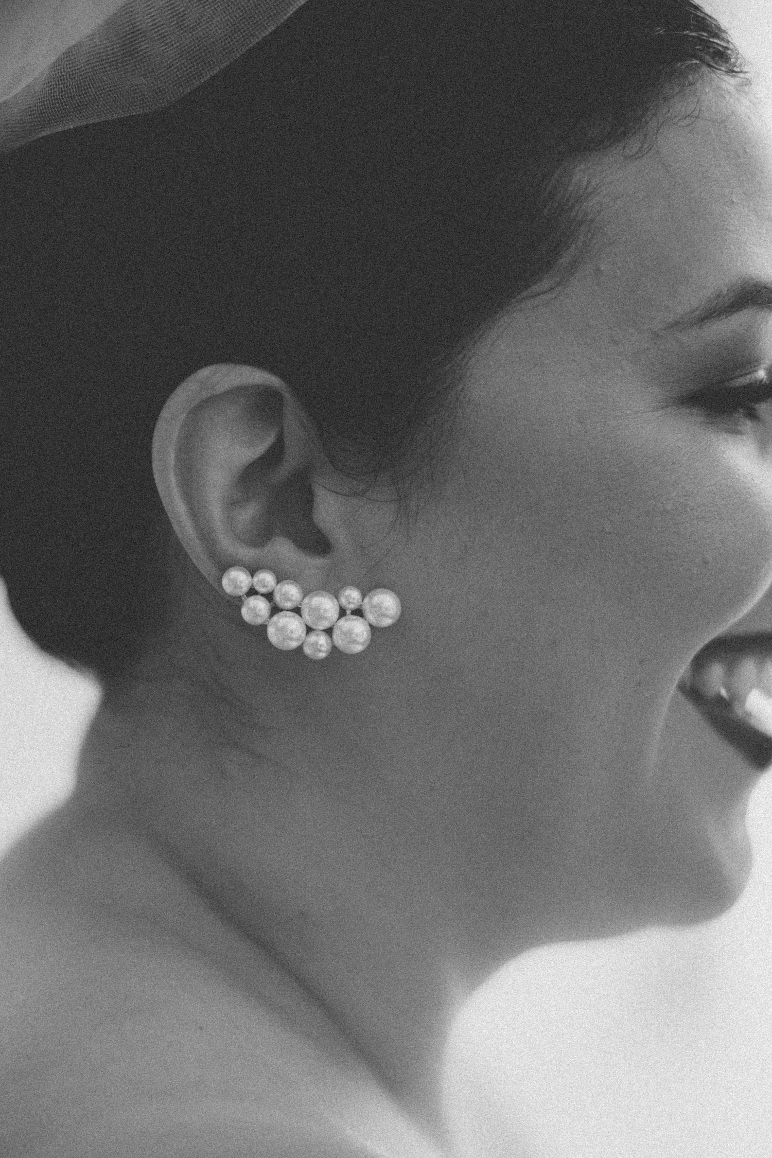Close up of shimmering pearl cluster earrings in black and white photography.