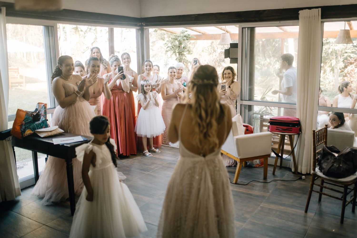 Wedding party watching emotional first look reveal at indoor reception venue.