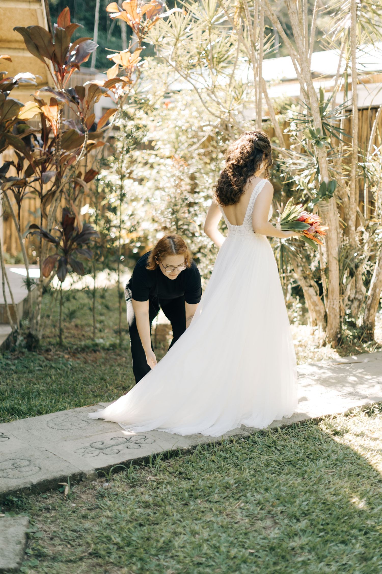 First look moment at an outdoor wedding ceremony with flowing white dress and natural garden setting.