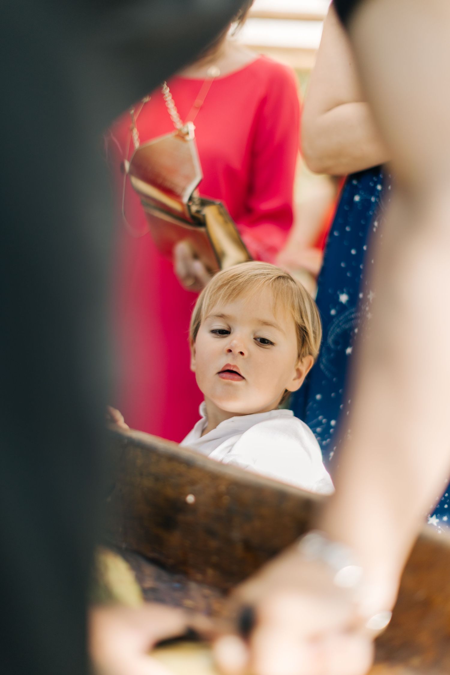 A child gets their hair styled in soft focus with red and navy colors in the background.