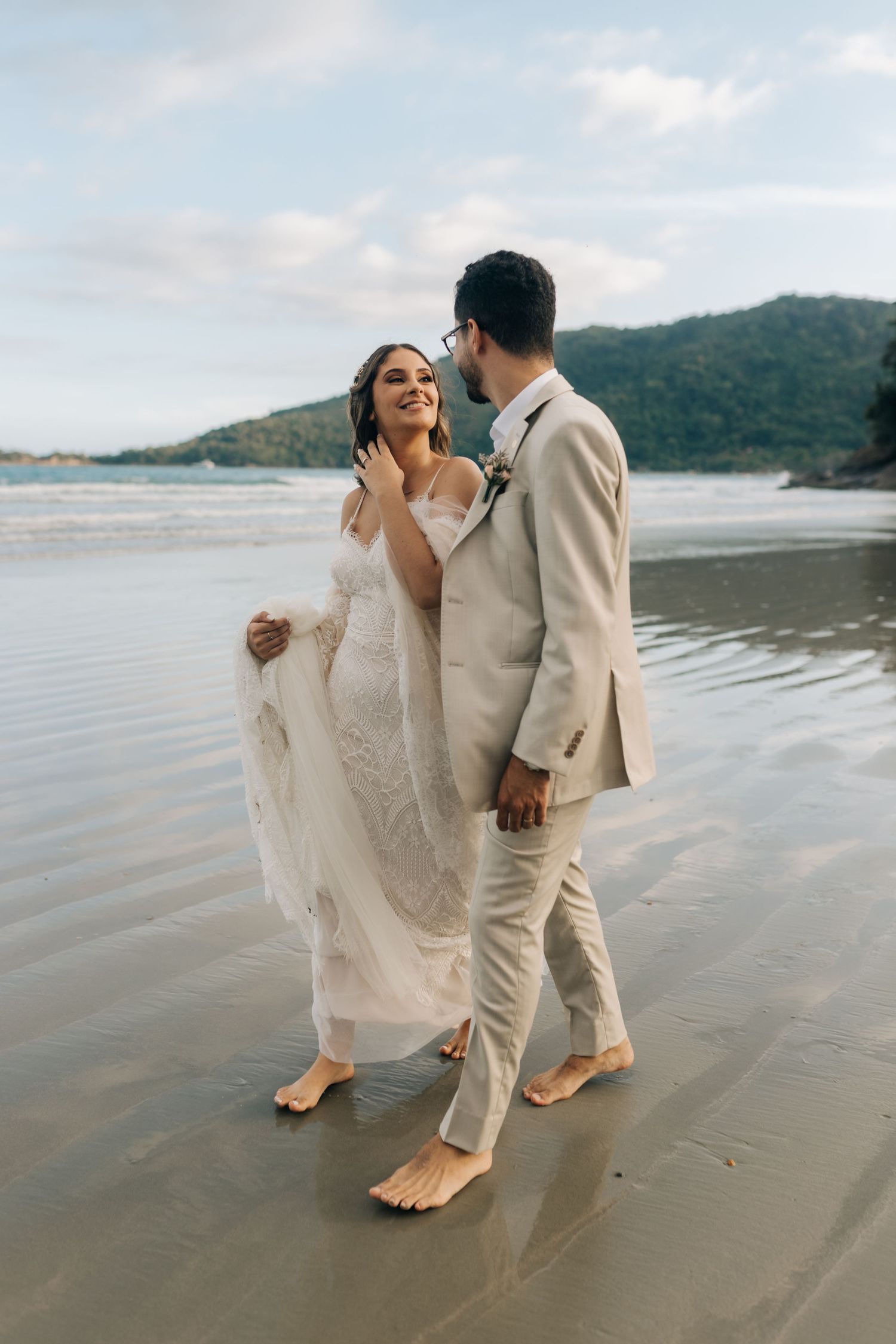 Romantic beachside portrait of newlyweds sharing an intimate moment by the ocean.