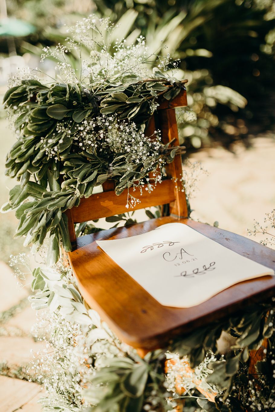 Wedding guest book decorated with delicate greenery and baby's breath flowers.