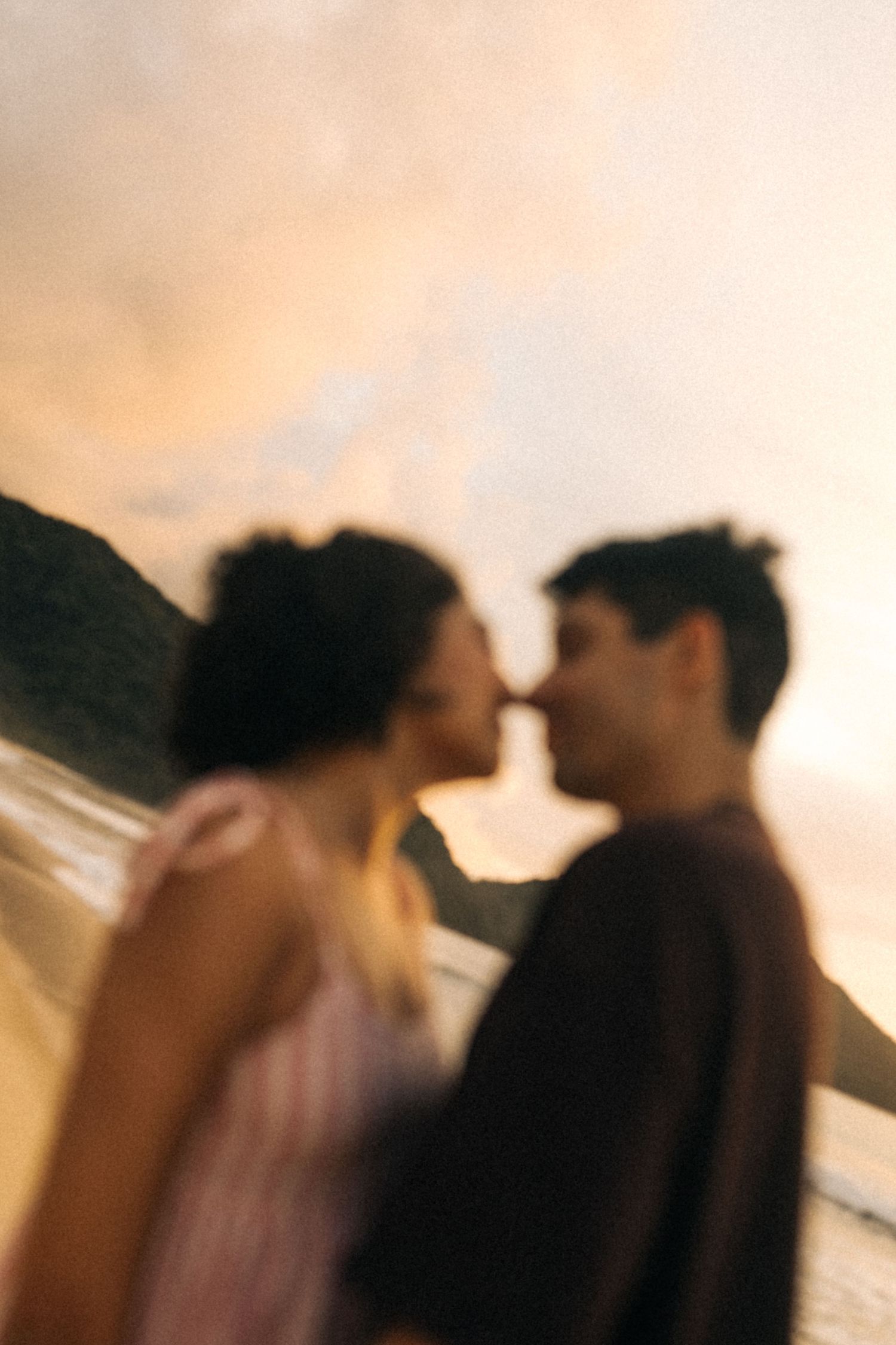 Uma silhueta artística turva de um casal romântico em foco suave contra um céu quente do pôr do sol.